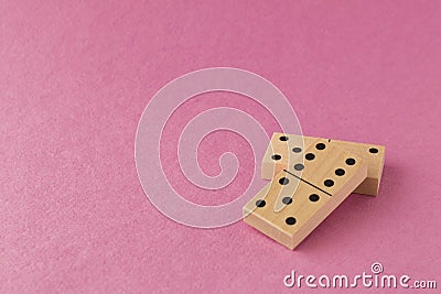 Playing dominoes on a pink background. Leisure games concept. Domino effect. Selective focus Stock Photo