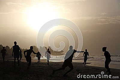 Playing football on the gambian beach Stock Photo