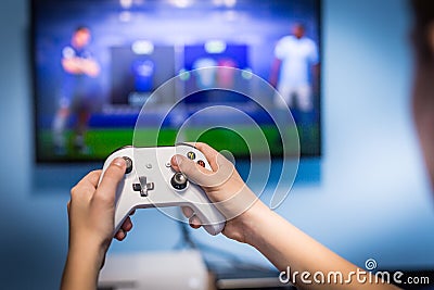 Video gaming and game play on tv fun gamer holding game-pad and controller video console playing and enjoying with blurred screen Stock Photo