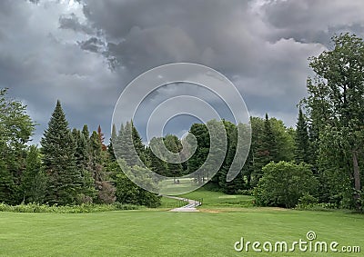 A green golf course and blue stormy sky on a beautiful summer day in Canada Stock Photo