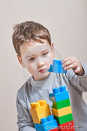 Playing little boy with colored cubes Stock Photo