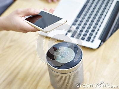 Playing music through a portable blue-tooth speaker Stock Photo