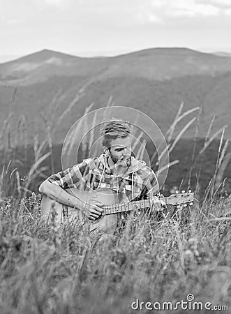 Playing music. Silence of mountains and sound of guitar strings. Hipster musician. Inspiring environment. Man musician Stock Photo