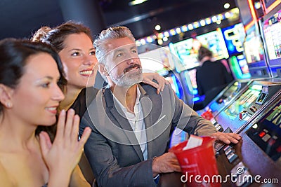 Playing slot machines at casino with girls Stock Photo