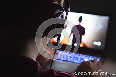 Playing video games with laptop. Young man plays action game. Stock Photo