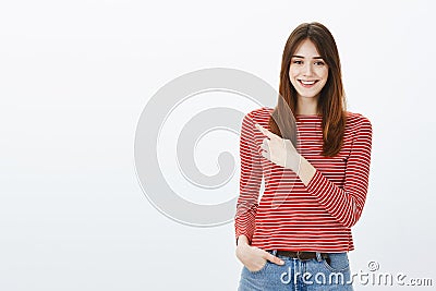 Pleasant attractive girl showing way out. Portrait of friendly confident european girlfriend with positive attitude Stock Photo