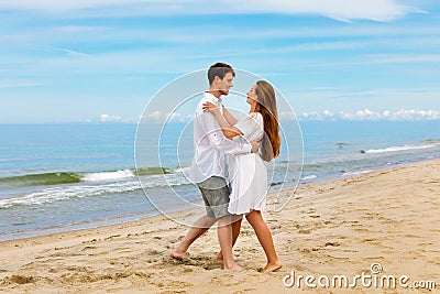 Pleasant couple of young people in love dancing on the sea beach Stock Photo
