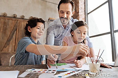 Pleasant family being immersed into painting process Stock Photo