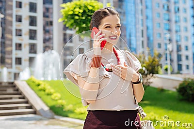 Pleasant happy woman putting a phone to her ear Stock Photo