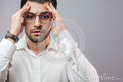 A pleasant man looking down as he has a headache Stock Photo