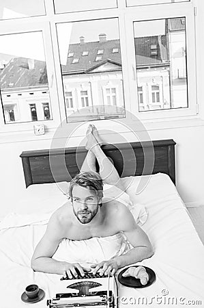 Pleasant occupation. Man writer lay bed bedclothes working book. Writer romantic author used old fashioned typewriter Stock Photo