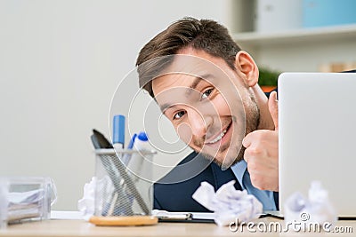 Pleasant office worker hiding behind laptop Stock Photo