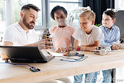 Pleasant robotics specialist conducting a workshop for children Stock Photo