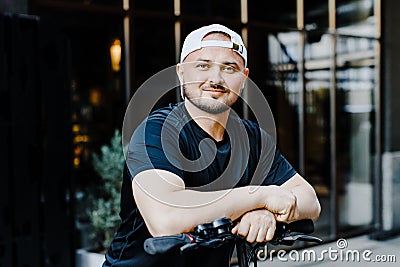 Pleasant smiling man riding a kick scooter Stock Photo