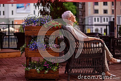 Pleasant smiling woman is resting in the armchair and enjoying her life Stock Photo