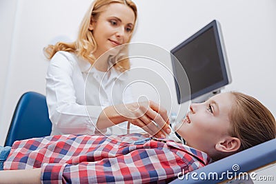 Pleasant young sonographer providing ultrasonic neck examination at work Stock Photo