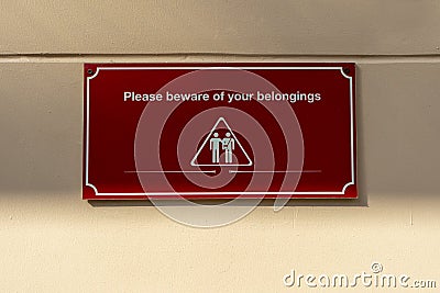 Please beware of your belongings sign on wall Stock Photo