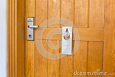 Please do not disturb sign on Closed wooden door of hotel room Stock Photo