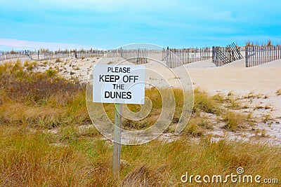 PLEASE KEEP OFF THE DUNES sign with beautiful dunes and blue sky background Stock Photo