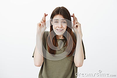 Please, my dreams need come true. Portrait of impatient and worried cute woman in casual t-shirt, raising crossed Stock Photo