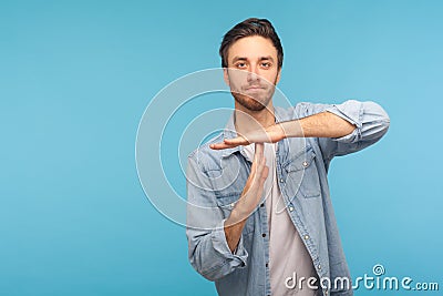 Please, need pause! Portrait of man in worker denim shirt showing time out, refusing and doing enough limit gesture Stock Photo