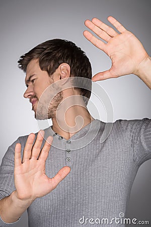 Please, no! Portrait of young men expressing negativity and gesturing while standing isolated on grey Stock Photo