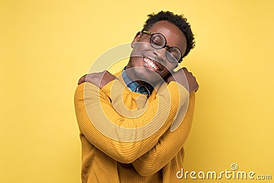 Pleased african american man hugs himself, has high self esteem Stock Photo