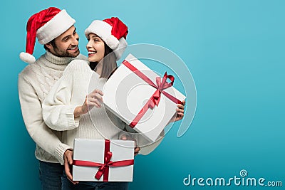pleased couple in santa hats holding Stock Photo