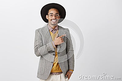 Pleased creative designer showing his new invention. Confident attractive male model in stylish black hat and formal Stock Photo