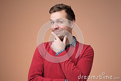 Pleased grinning tricky man having some intention in mind, smiling with curious Stock Photo
