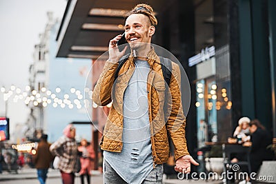 Pleased young man having friendly conversation on the phone Stock Photo