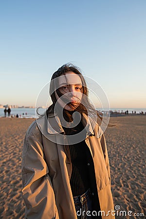 Pleasing girl portrait in wearing a cloak on the sea coast Stock Photo