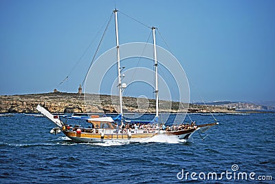 A pleasure boat with lots of sightseers aboard heading back to the sea . Stock Photo