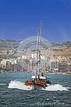 A pleasure boat with lots of sightseers aboard heading back to the shore . Stock Photo