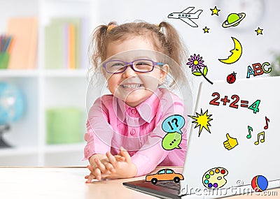 Pleasured kid using notebook actively with great interest as multimedia encyclopedia and game center Stock Photo