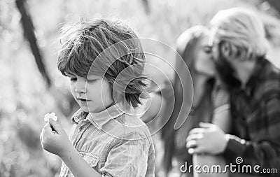 Pledge of love. Little child with couple kissing on background. Small child hold spring flower. Cute boy child sunny day Stock Photo