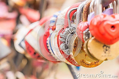 Plenty of multicolored love padlocks on metal railing of the bridge. selective focus, toned Stock Photo