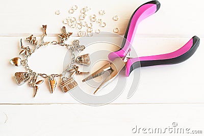 Pliers, bracelet, metal ring on a white wooden background. How to do yourself metal bracelet. Step Stock Photo