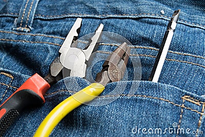 Pliers and screwdriver on bag jean background Stock Photo