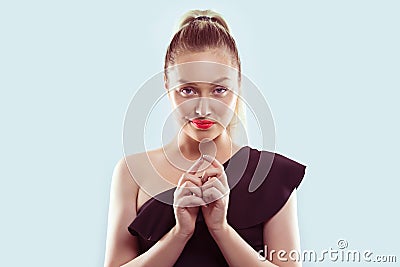 Plot. Closeup portrait of sneaky, sly, scheming young woman plotting something isolated on light blue background. Negative human Stock Photo