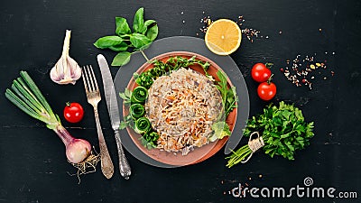 Plov Rice with meat and vegetables on a plate. Uzbek cuisine. On a wooden background. Top view Stock Photo