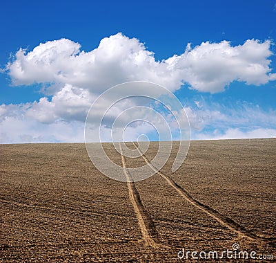 plowed field with cloudly sky, farmland in spring Stock Photo