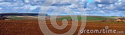 A plowed land with an agrarian landscape of the springtime with beautiful cloudly sky Stock Photo