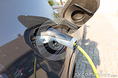Plug in electric car to charge Stock Photo