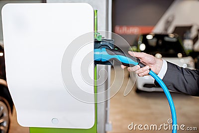 Plugging cable into the charging station Stock Photo