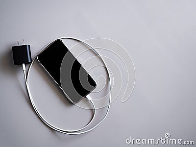 Plugging a Charger Mobile on White wall background Stock Photo
