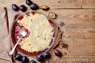 Plum crumble with aromatic spice on wooden rustic table top view. Autumn pastry. Stock Photo