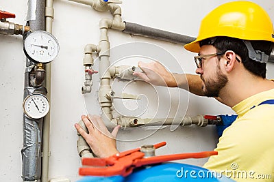 Plumber doing maintenance jobs for water and heating systems Stock Photo