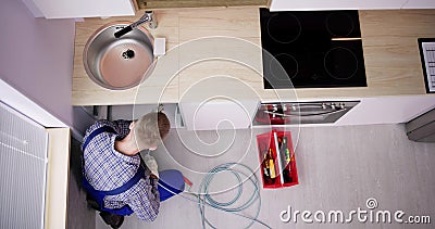 Plumber Drain Cleaning Services In Kitchen Stock Photo