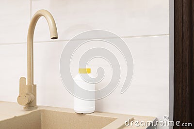 Plumber drain granules in White Plastic Bottle With Yellow Cap On Kitchen Sink In Cook Stock Photo